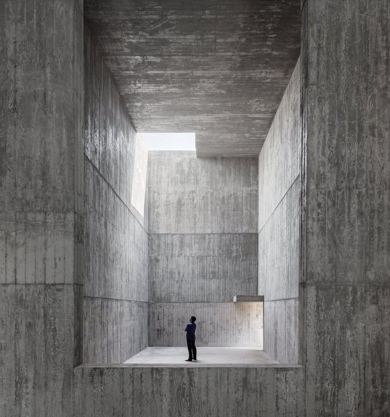 A man stands in the vast concrete gallery at the Saya Park project in South Korea.