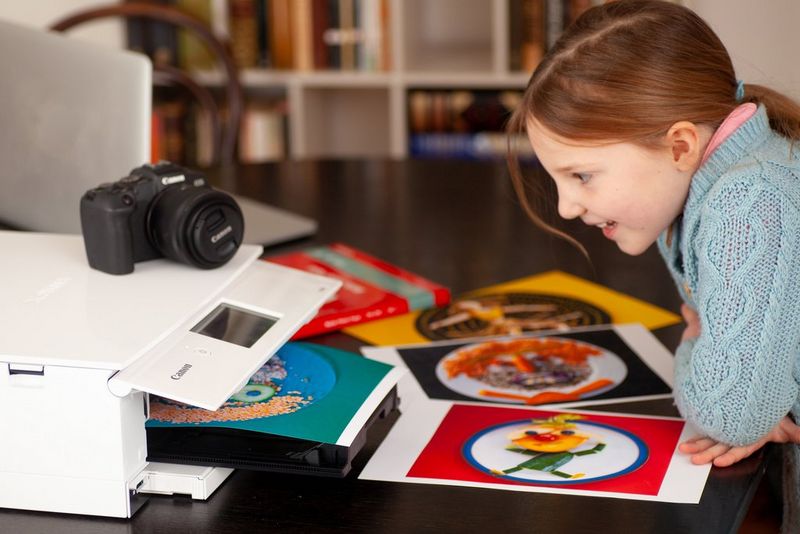 A young girl watching a Canon PIXMA TS8351 printing out colourful food face images. 