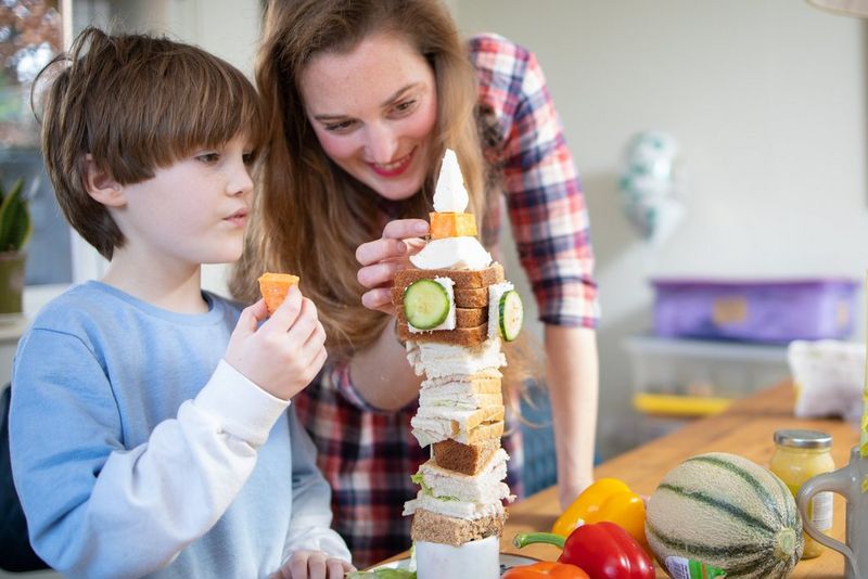 A mother and son creating a tower of food to resemble London's Big Ben clock tower.