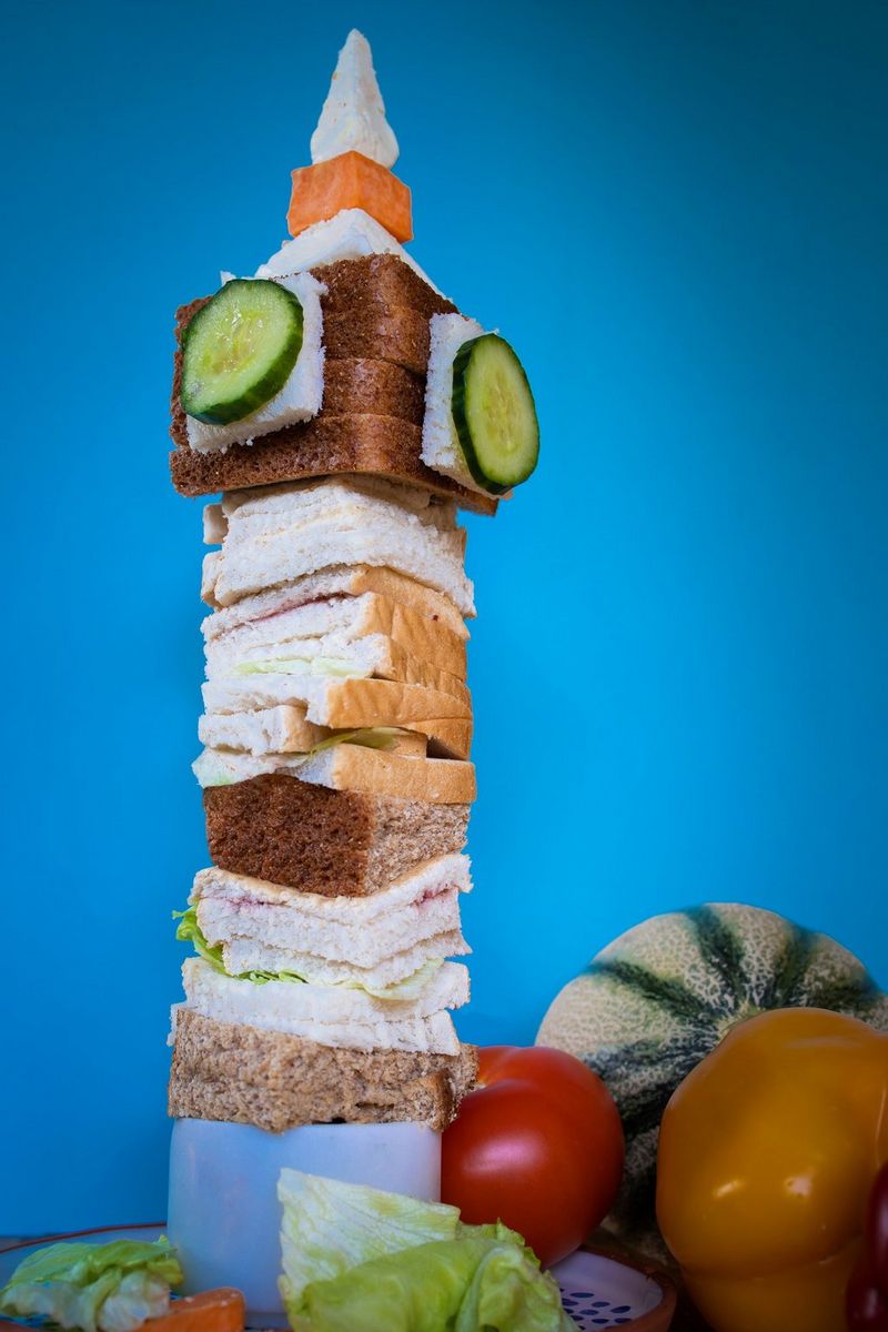 A statue of the Big Ben clock tower in London made out of bread, cheese and cucumber.