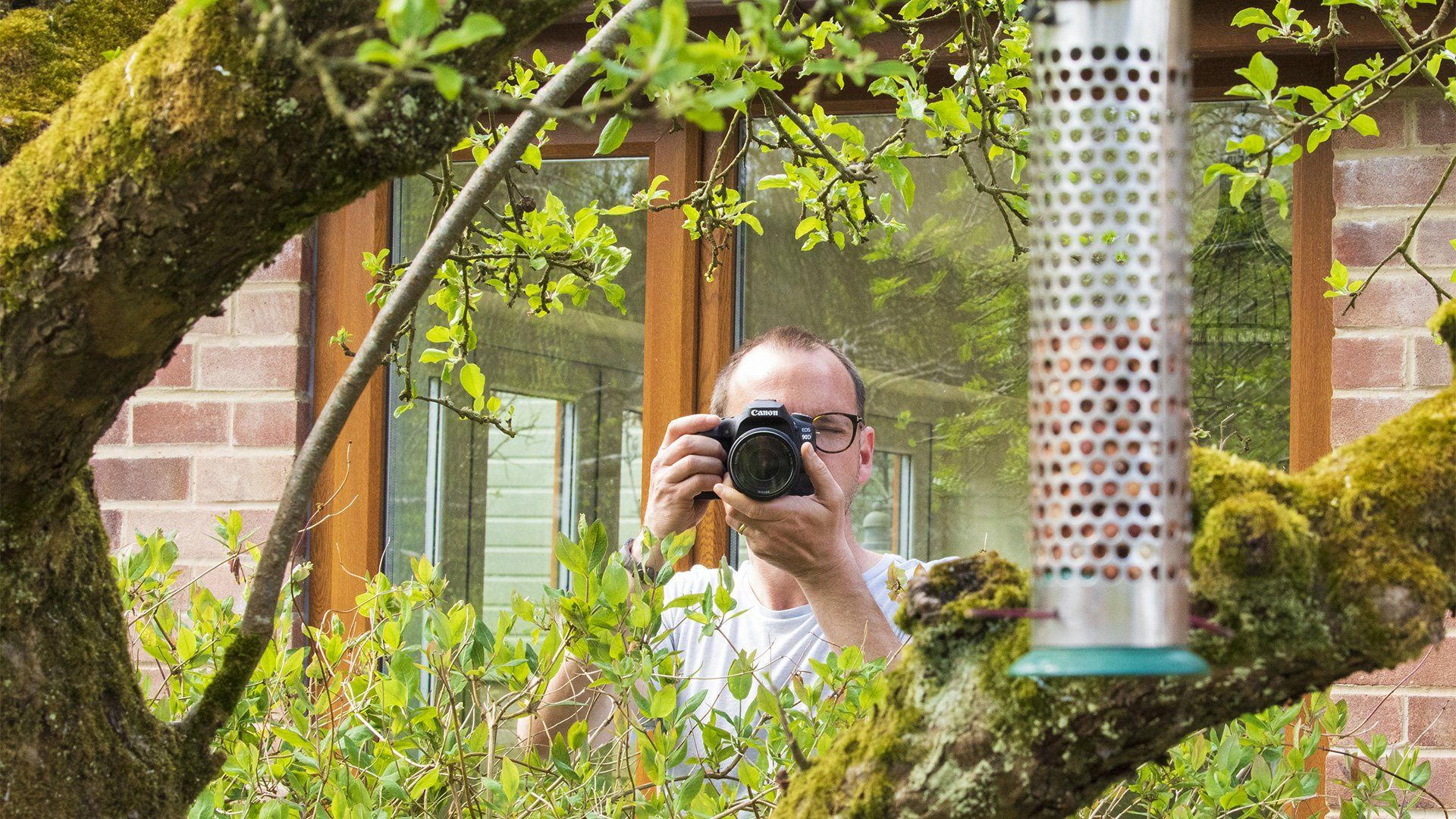 James Paterson photographing a bird feeder in his garden.