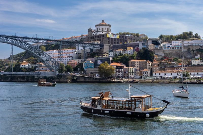 A boat cruises along at midday on the Douro River in Porto, Portugal. Taken on a Canon EOS R6 with a Canon RF 24-105mm F4-7.1 IS STM lens.
