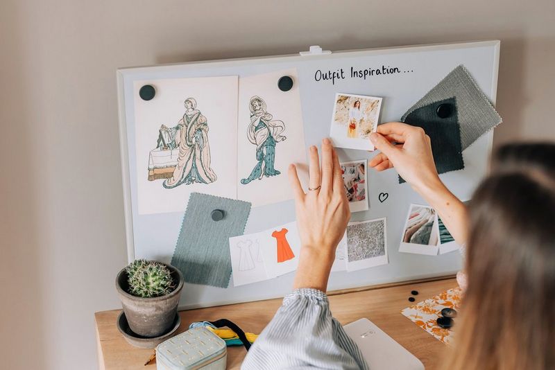 A woman making an outfit inspiration mood board, attaching SELPHY Square QX10 images alongside drawings and material swatches. 