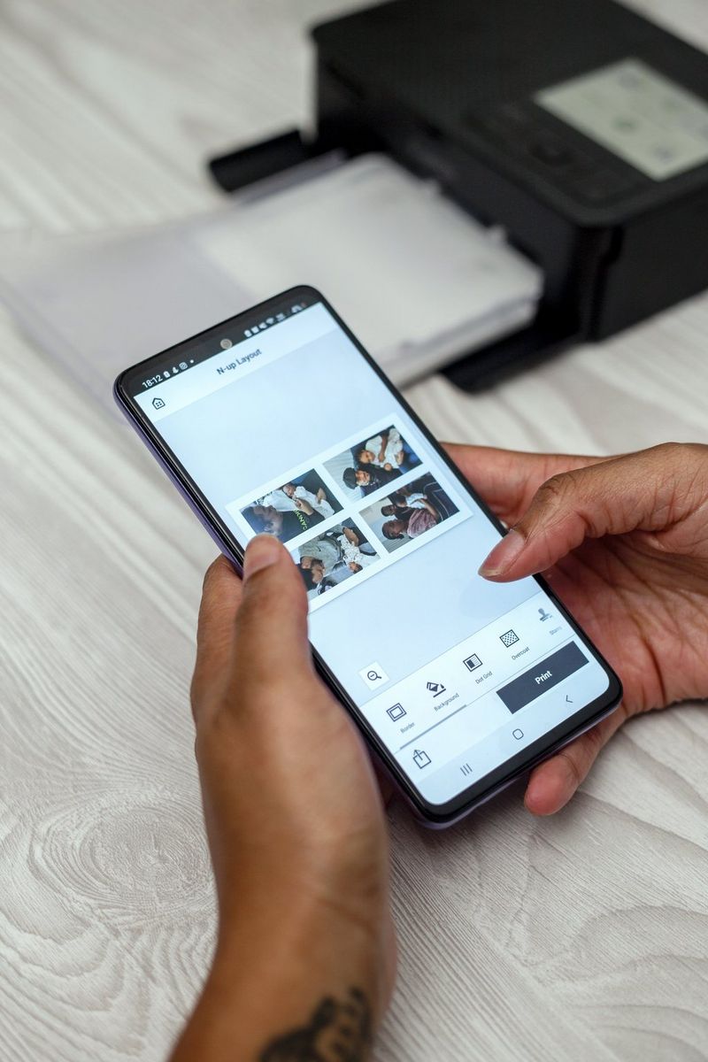 A person uses the Canon SELPHY Photo Layout app on their smartphone to create a collage of four photos.