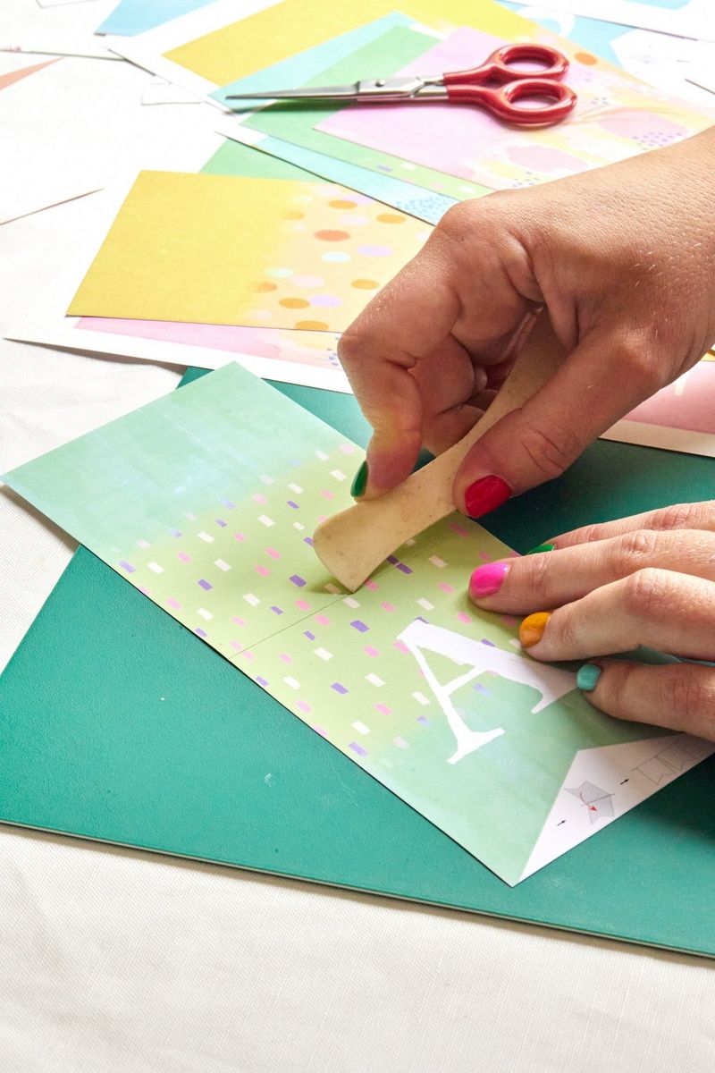 A pair of hands scores a Canon Creative Park template before folding it. 