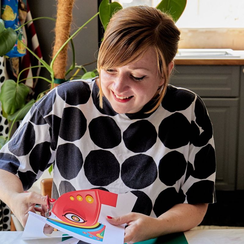 Designer Pippa Hiscock smiles as she cuts out a papercraft template printed on a Canon PIXMA printer via the Canon Creative Park app.