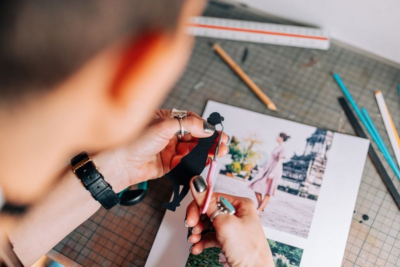 A person carefully cutting out the silhouette of a woman. 