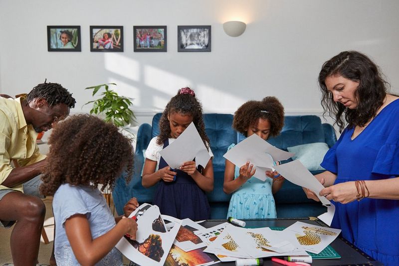 A whole family sat in a living room cutting out paper templates.