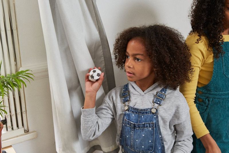 A girl preparing to throw a paper football.