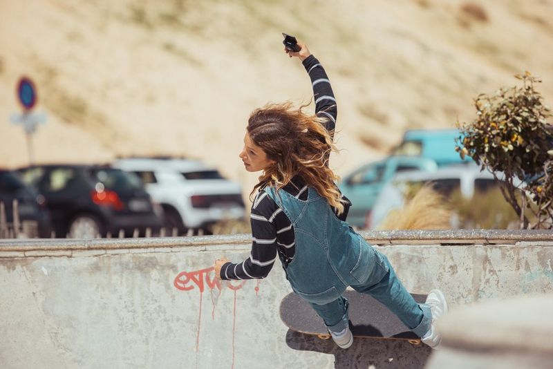 Sports vlogger Manon Lanza holds a Canon PowerShot V10 out to capture her movements as she rides a skateboard up a skate ramp. 