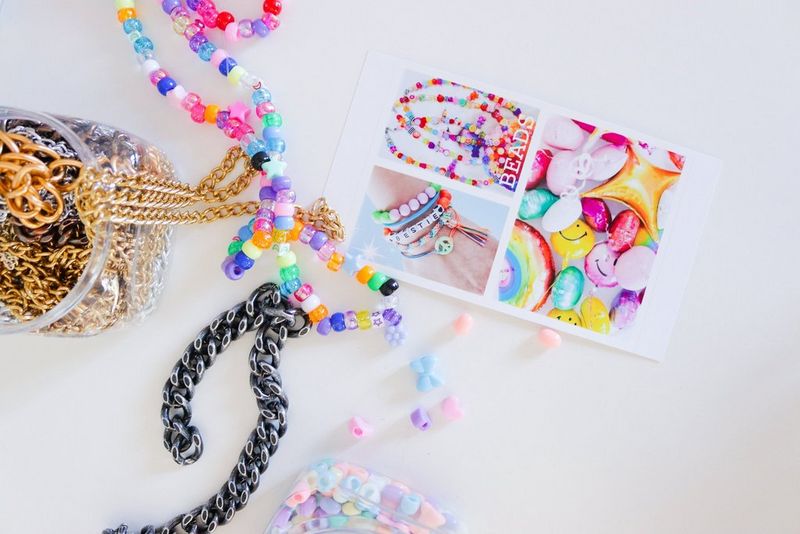An array of beads and necklaces beside a piece of paper with images of bead necklaces and bracelets.