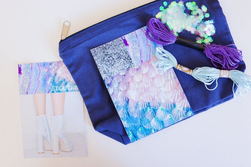 A makeup bag with a sparkly sheet, string and sequins placed on it, besides a picture of a pair of white boots with a shiny, holographic effect.