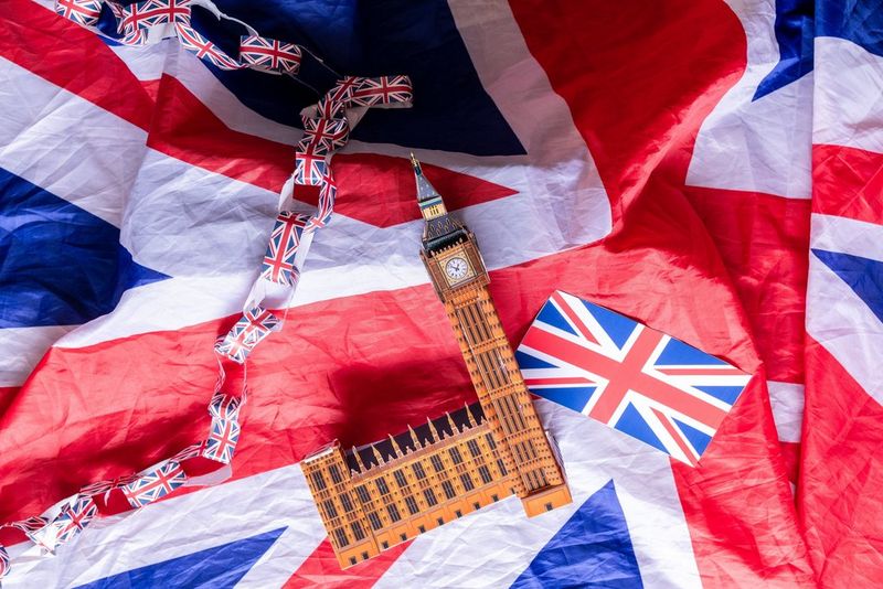 A papercraft model of Big Ben positioned on a Union Jack flag.