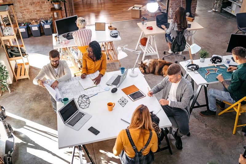 An image of work professionals working together around a large table