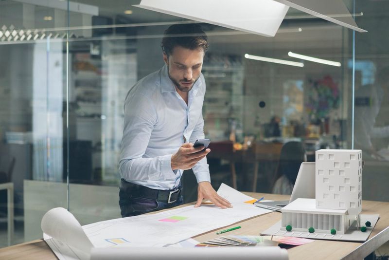 man looking at this phone in an office