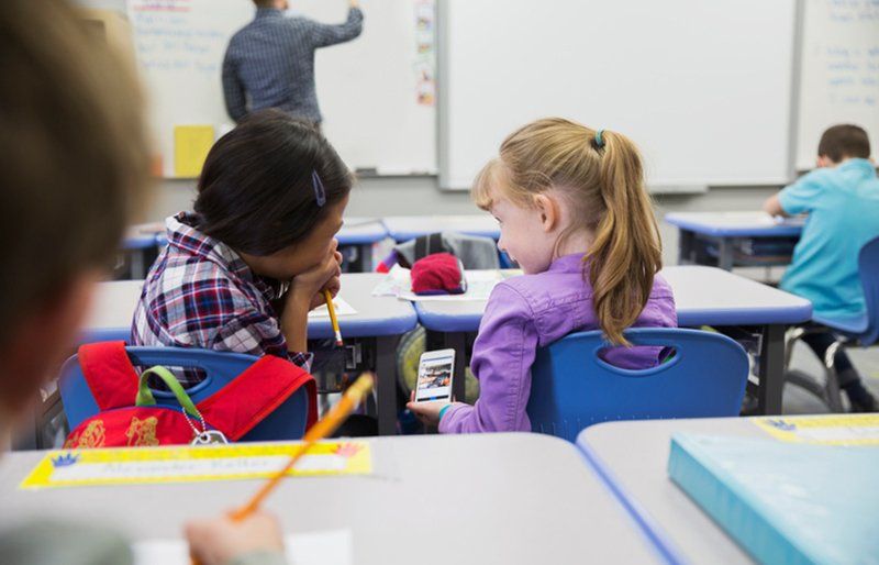 Teacher helping children learning maths