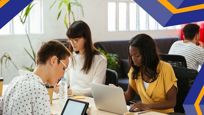 An image of people working on their laptops in an office