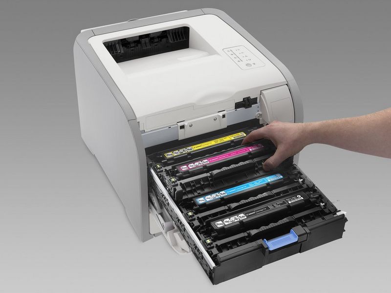 A hand replaces a magenta toner cartridge inside a Canon i-SENSYS laser printer.