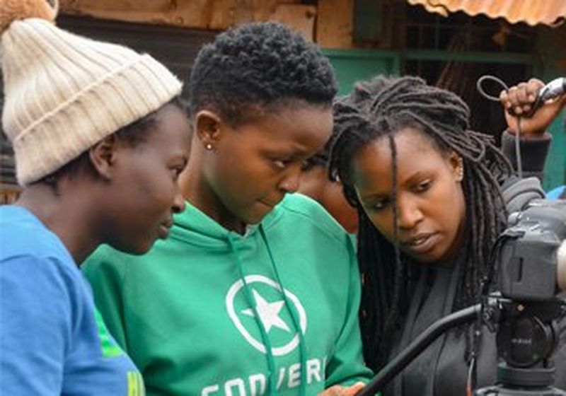 Three young women looking at the rear display of a camera