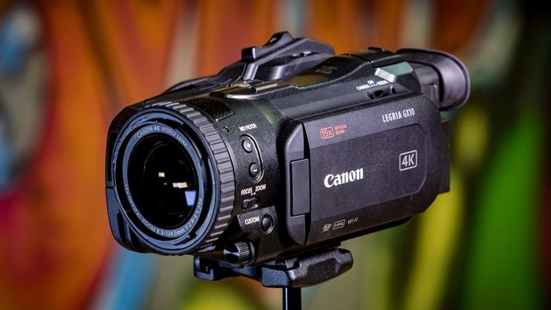 A LEGRIA GX10 camcorder on a tripod with colourful background