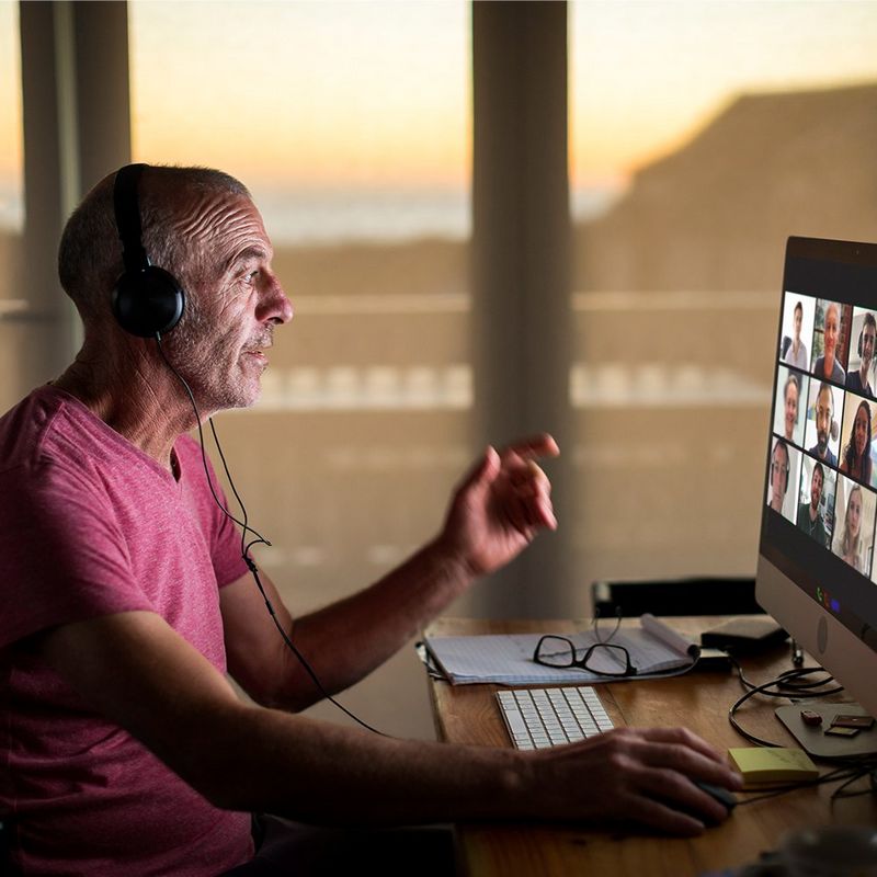 An image of a man talking to his work colleagues on a virtual call 