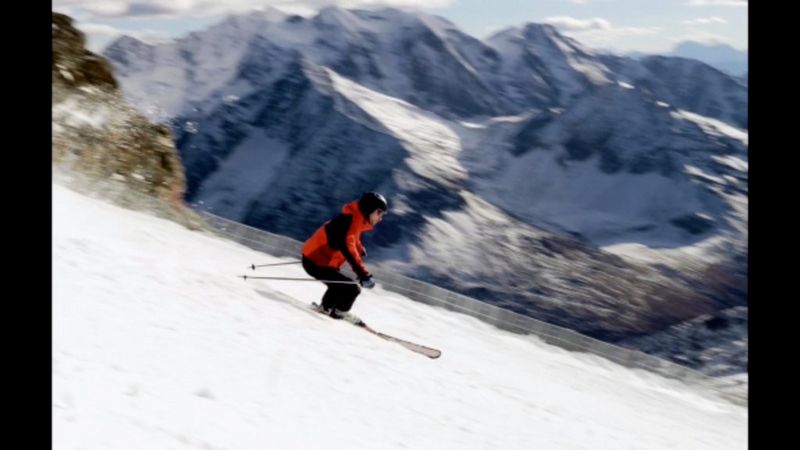 A skier speeding down a snowy mountain.