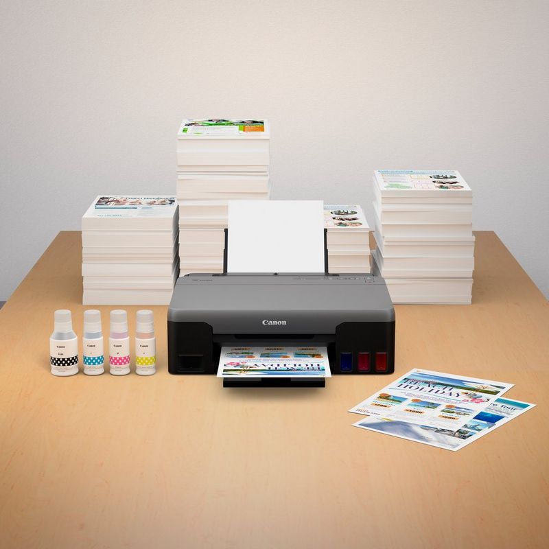 PIXMA G1520 with stack of photo prints and compatible inks in an office desk