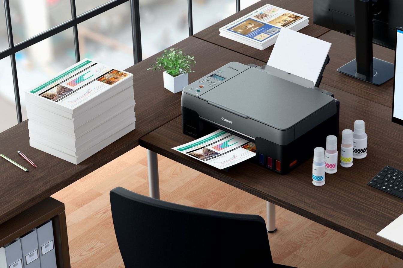A PIXMA G3460 kinyomtatott fotókkal és kompatibilis tintákkal egy irodai asztalon