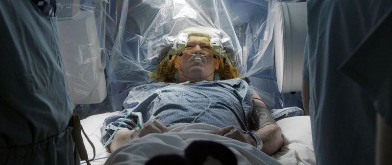 In a still from the documentary Hunting for Hedonia, a man lies having brain surgery in an operating theatre. 