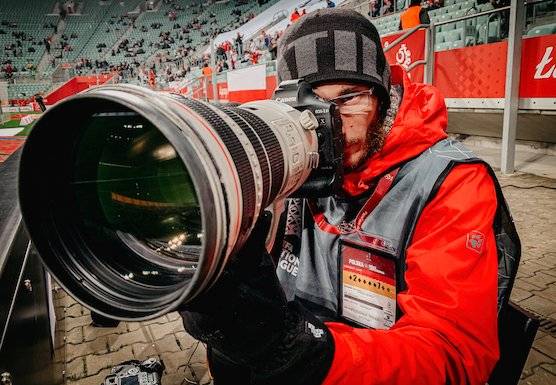 Photographer and Canon Ambassador Łukasz Skwiot with a large Canon lens.
