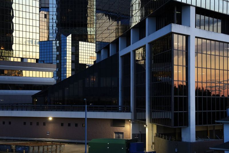 The evening sky is reflected in a series of glass-panelled buildings.