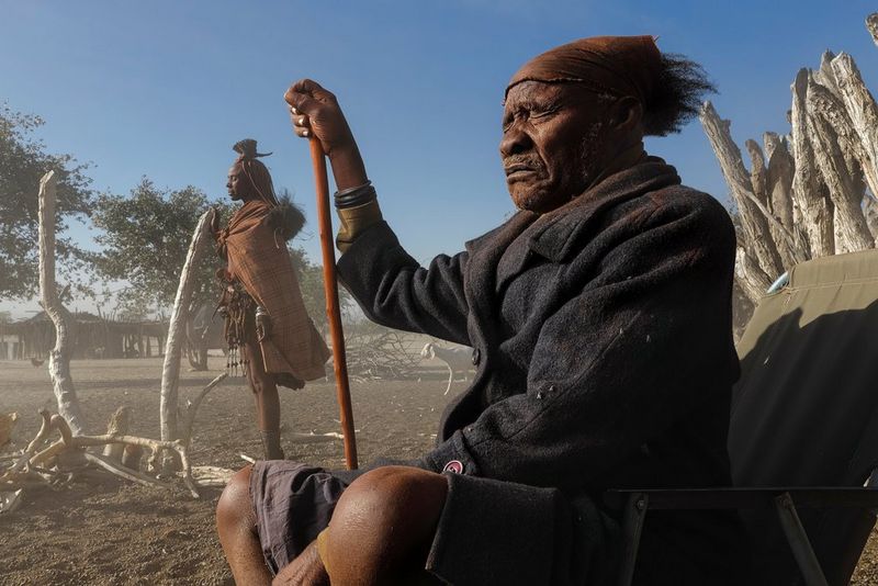 In a parched environment, a man and a woman – one seated, one standing – close their eyes tightly as dust blows around them. Taken by Brent Stirton on a Canon EOS R.