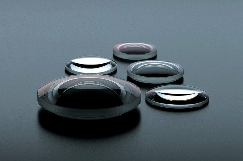 Five aspherical lenses of varying sizes.