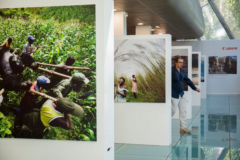 A man walks between white display boards at a photography exhibition.