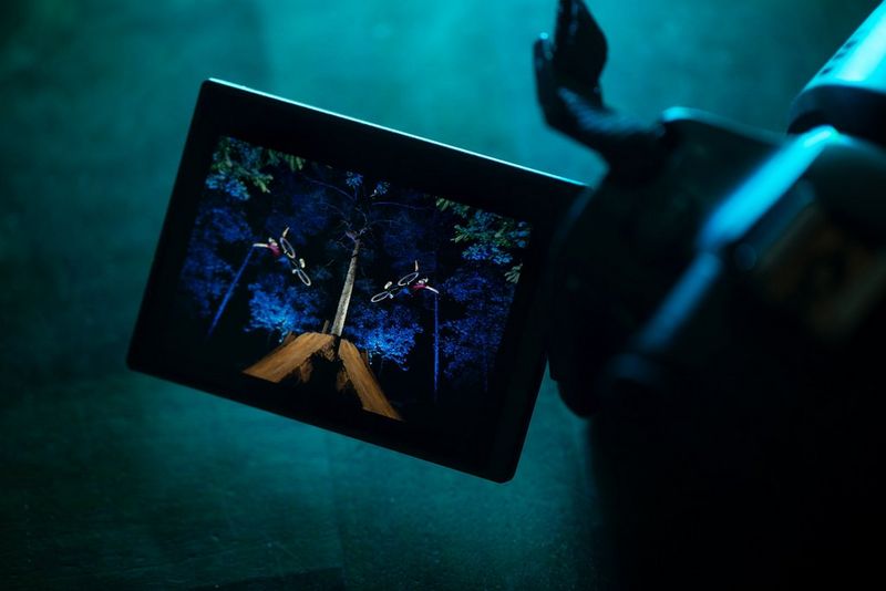 A mirror image of a rider making a daring leap with his arms held aloft displayed in the vari-angle touchscreen of a Canon EOS R5.  