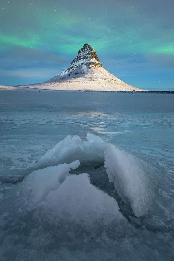 The aurora borealis over the ice at Kirkjufell, Iceland.  