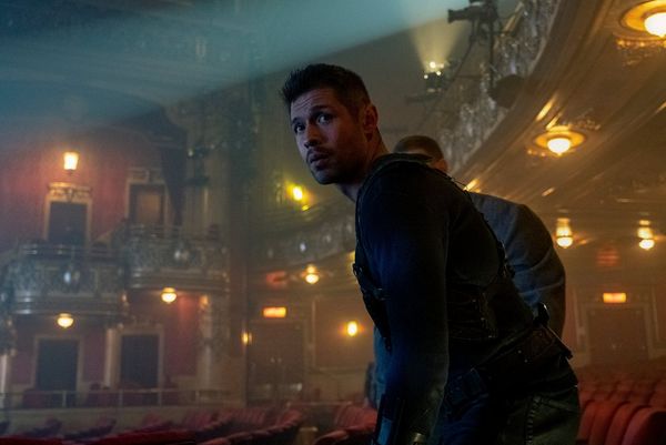 In a still from The Umbrella Academy, actors David Castañeda and Tom Hopper (behind) enter a misty theatre.