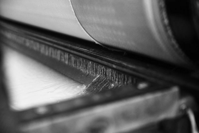 A black and white close-up of a cylinder mould paper machine.