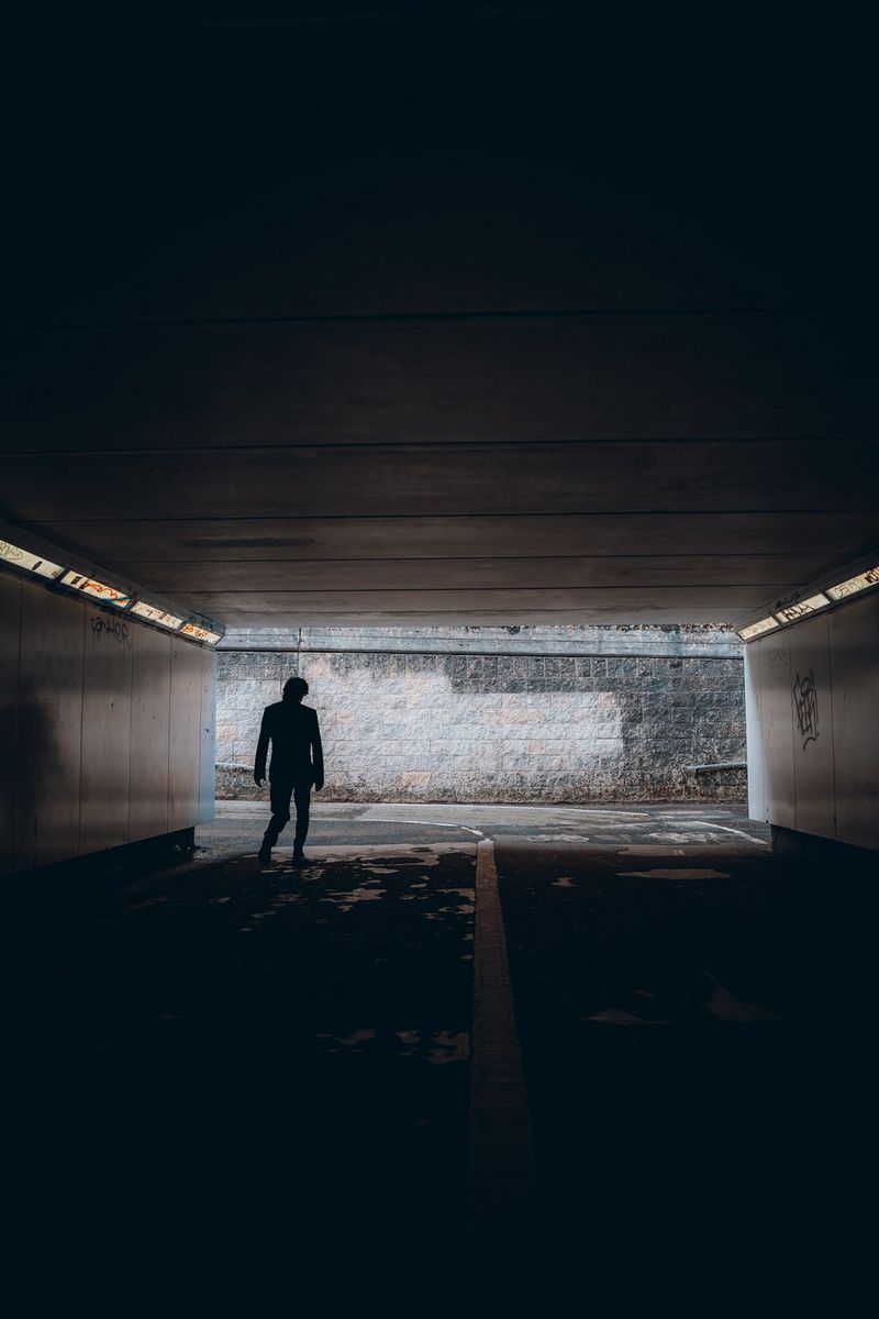 A figure in silhouette at the end of a long, graffiti-covered underpass. Taken by Andres McNeill with a Canon RF 28mm F2.8 STM lens. 
