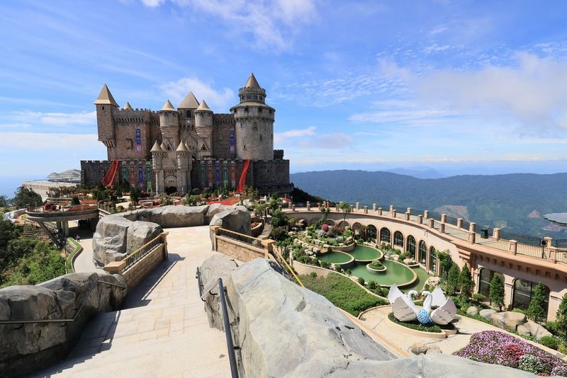 A castle-like structure with extensive grounds against a blue sky and mountain backdrop, taken with a Canon RF-S 10-18mm F4.5-6.3 IS STM lens.