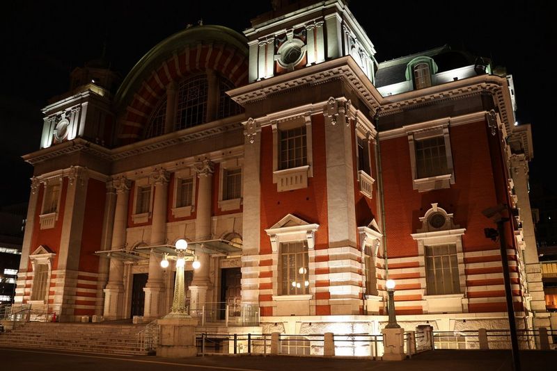 An ornately decorated building photographed under artificial lighting at night using an EOS R10, with good detail visible in both the brickwork and the highlights.