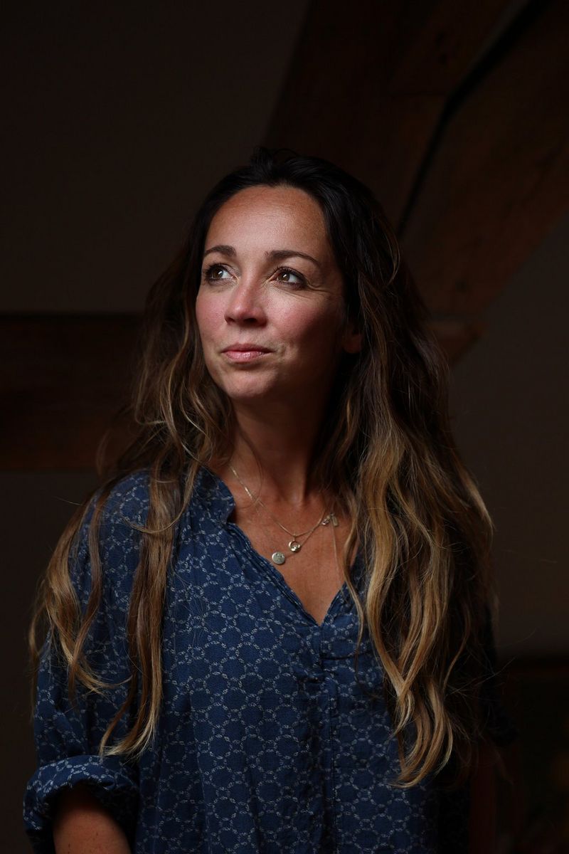 A portrait of a young woman in a blue blouse looking to her right, taken by Ilvy Njiokiktjien with a Canon RF 85mm F2 MACRO IS STM lens.