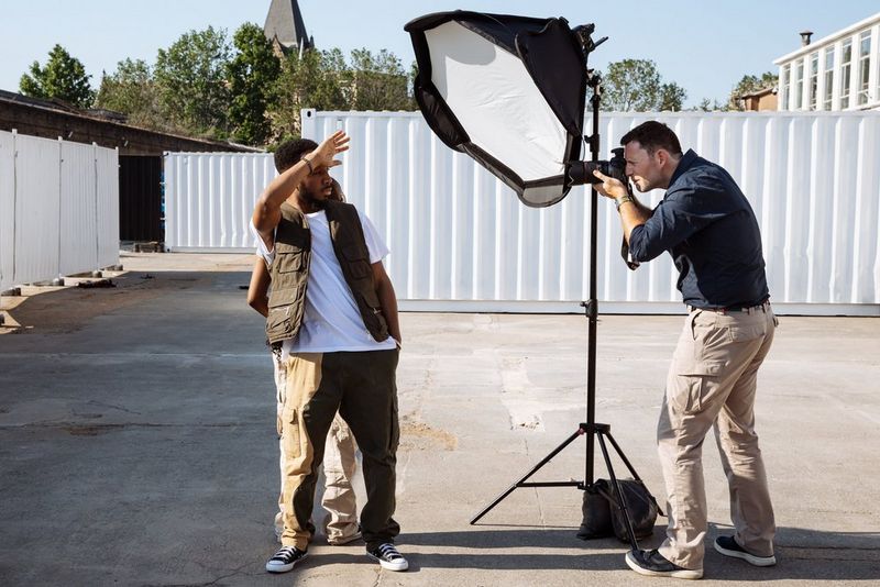 Photographer David Newton stands behind a softbox positioned close to his subjects.