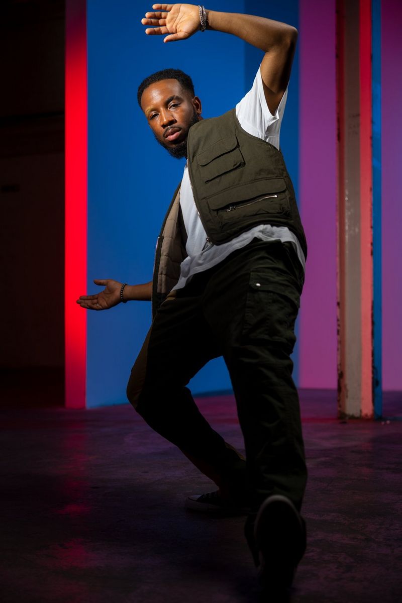 A dancer backlit by two Canon Speedlite EL-5s with coloured gels, lit from above by another Speedlite EL-5 and with another Speedlite EL-5 fired at the face using the low power mode.