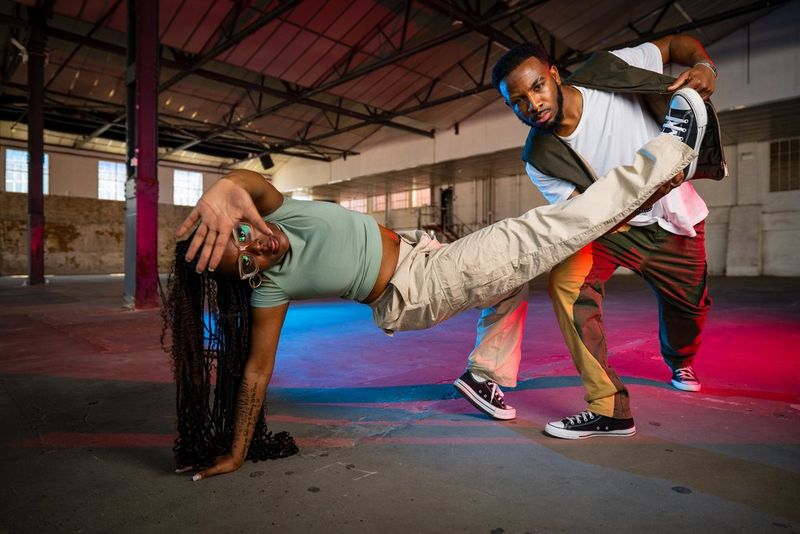 A man and a woman dancing in a warehouse lit by multiple Canon Speedlite EL-5s. 