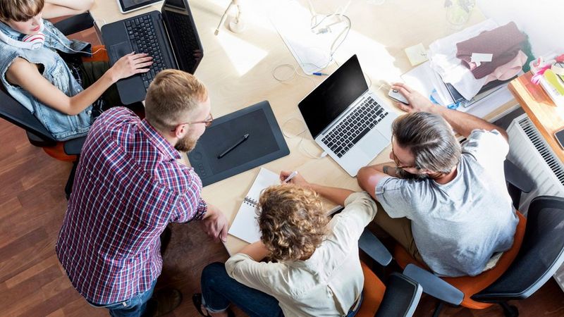 an image of work professionals working together around a table