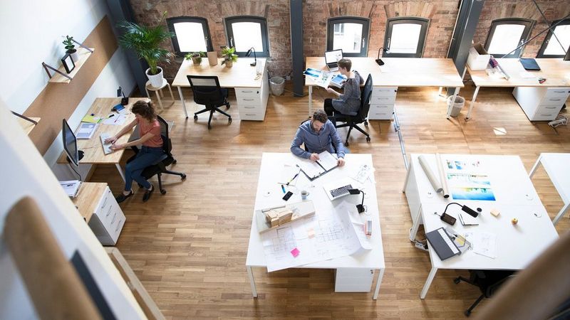 Work professionals sitting in an office working at their desks – Canon UK