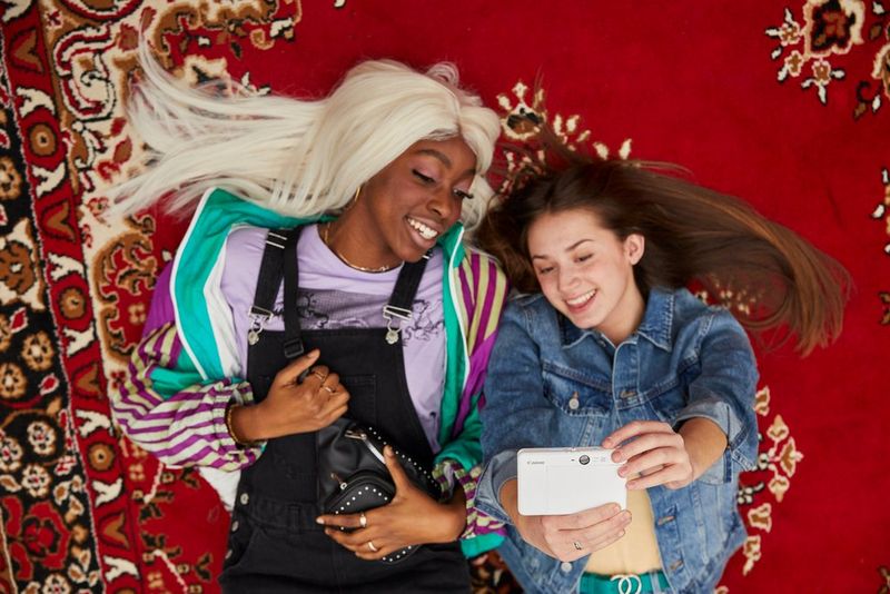Two young women posing for a selfie taken with a Canon Zoemini S2.