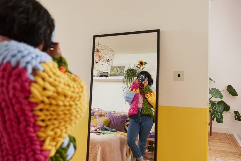 A woman taking a photo of herself in a mirror with the Canon Zoemini S2.