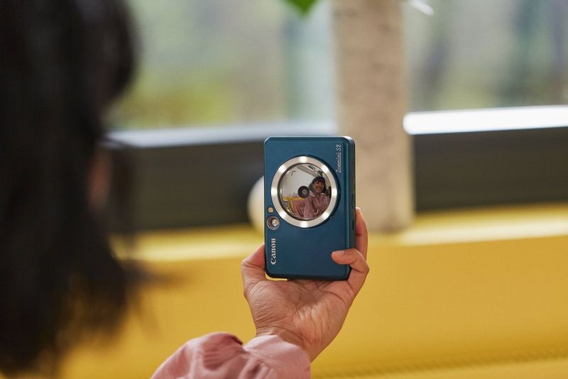 A person taking a selfie with the Canon Zoemini S II using the mirror and ring light.